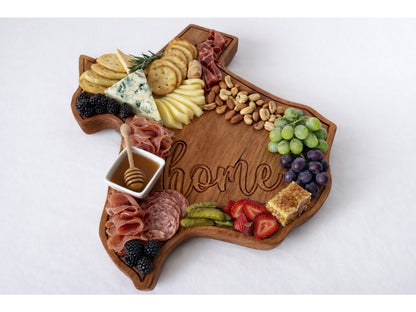 Texas shaped wooden serving board styled with charcuterie including cheese, meats, nuts, and fruit