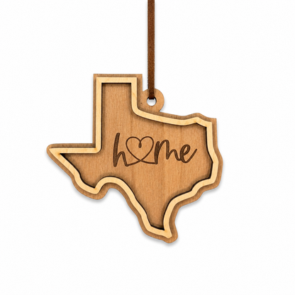 Wooden ornament shaped like the state of Texas with 'home' engraved on it.