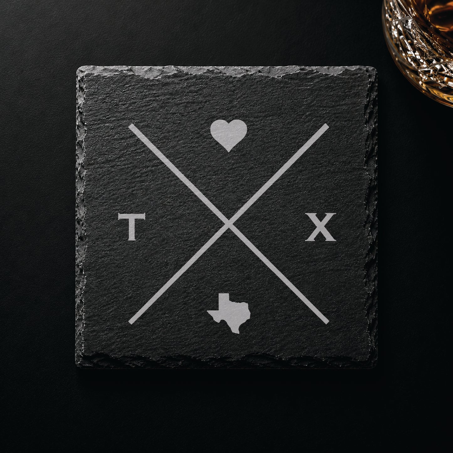 Dark slate coaster with engraved Texas crossed-line design, heart icon, and Texas silhouette on a dark background.