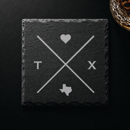 Dark slate coaster with engraved Texas crossed-line design, heart icon, and Texas silhouette on a dark background.