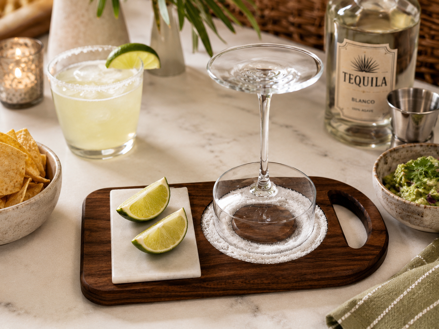 Lifestyle photo of walnut wood margarita rimmer styled with margaritas, citrus, and cocktail bar accessories.