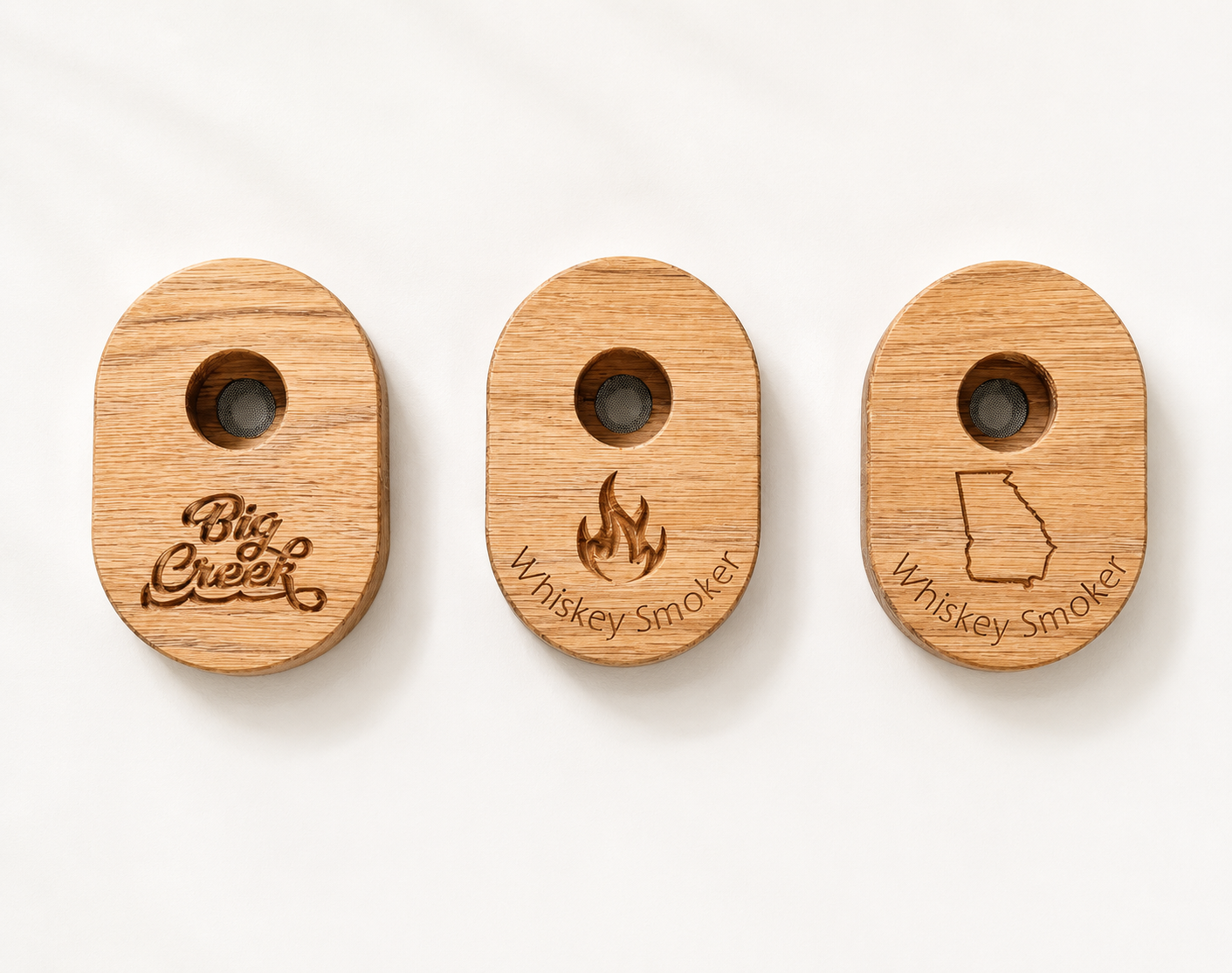 Three wooden whiskey smokers displayed side by side showing design options: custom logo, flame design, and Georgia state outline.